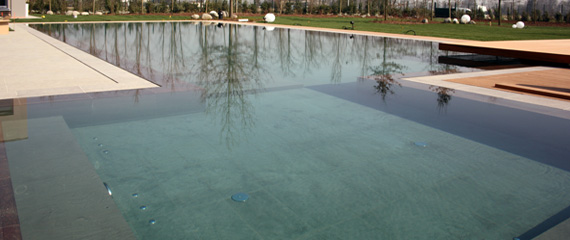 Acquafertpool piscina a bordo a sfioro a filo rivestita in pietra naturale