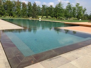 Acquafertpool Piscina privata rivestita in pietra naturale e sfioro a filo (1)