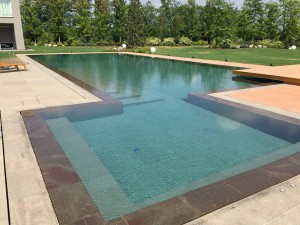 Acquafertpool Piscina privata rivestita in pietra naturale e sfioro a filo (2)